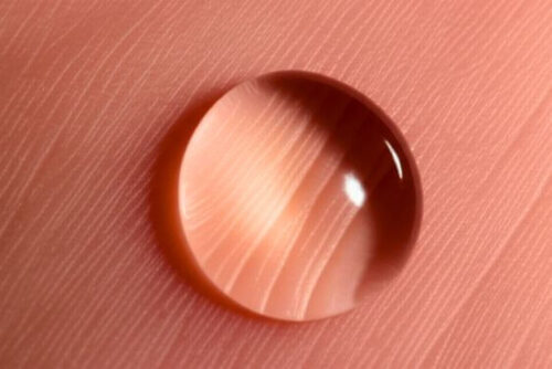 Fotografia macro e texturizada da pele humana, destacando poros e a textura sutil da epiderme para evocar a sensação de presença no corpo e a energia vital.